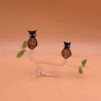 blown glass owls sitting on a branch