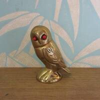 Vintage brass owl ornament with coral-coloured glass eyes