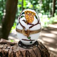 Une chouette délicate orne un oeuf musical, une porcelaine de Limoges renfermant un hibou min