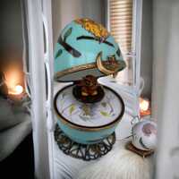 Une chouette délicate orne un oeuf musical, une porcelaine de Limoges renfermant un hibou min