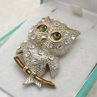 A superb owl costume jewelry brooch made in goldtone and silvertone metal set with sparkly clear whi