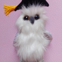 Ty beanie baby OWL soft, white fur, large eyes, and a black graduation cap with a yellow tassel.