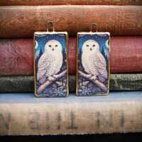 Handmade ceramic charms: illustration of a snowy owl sat on a branch with a 24kt gold lustre edge
