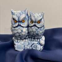 Blue ceramic owls on purch statue
