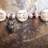 Owl bracelet with Czech owl coins, owl charm, Czech faceted opal cream rondelles, and Toho seed bead